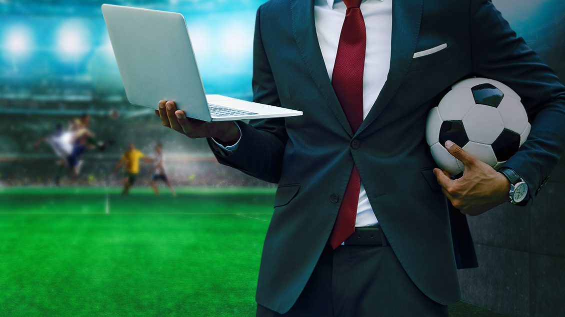 Ihminen pitelemässä palloa ja läppäriä